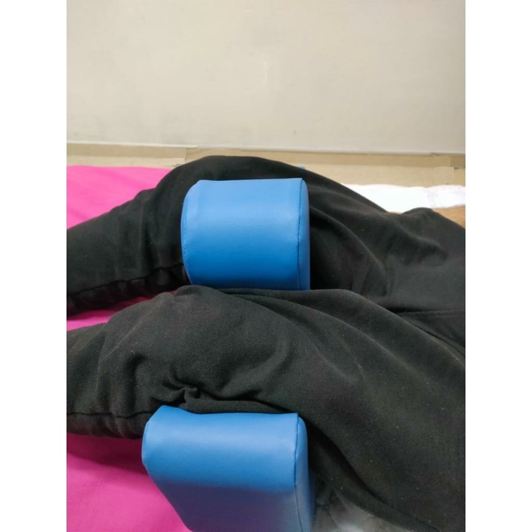 Постурална опора за позициониране на крака – ергономична форма от пяна с PVC покритие и странични дръжки.