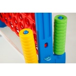 Голяма цветна версия на играта Печелившата четворка с червена решетка и дискове в жълт, зелен и червен цвят, поставена на синя стойка, подходяща за игра на открито и закрито.